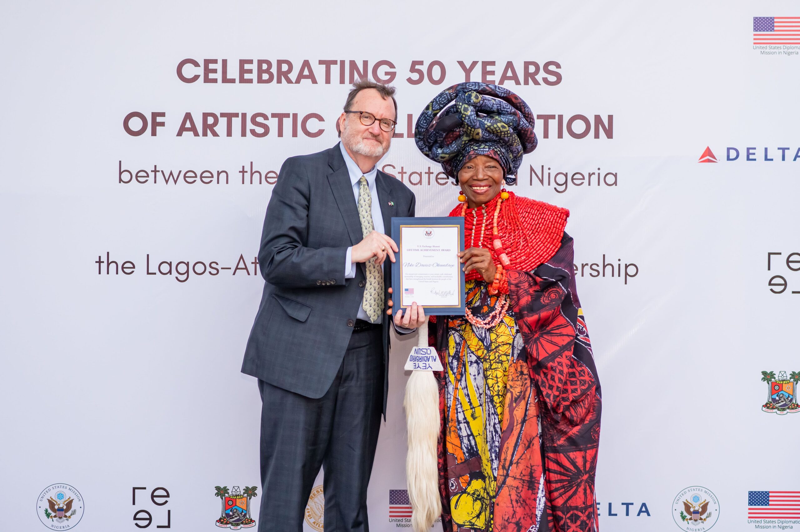 U.S. Ambassador Richard Mills (left); with founder of Nigeria's renowned Nike Art Gallery, Chief Nike Davies-Okundaye, during the U.S. Exchange Alumni Lifetime Achievement Award organized in commemoration of the 50 years of artistic collaborations between the United States and Nigeria and the 50-year Sister Cities partnership between Lagos and Atlanta.